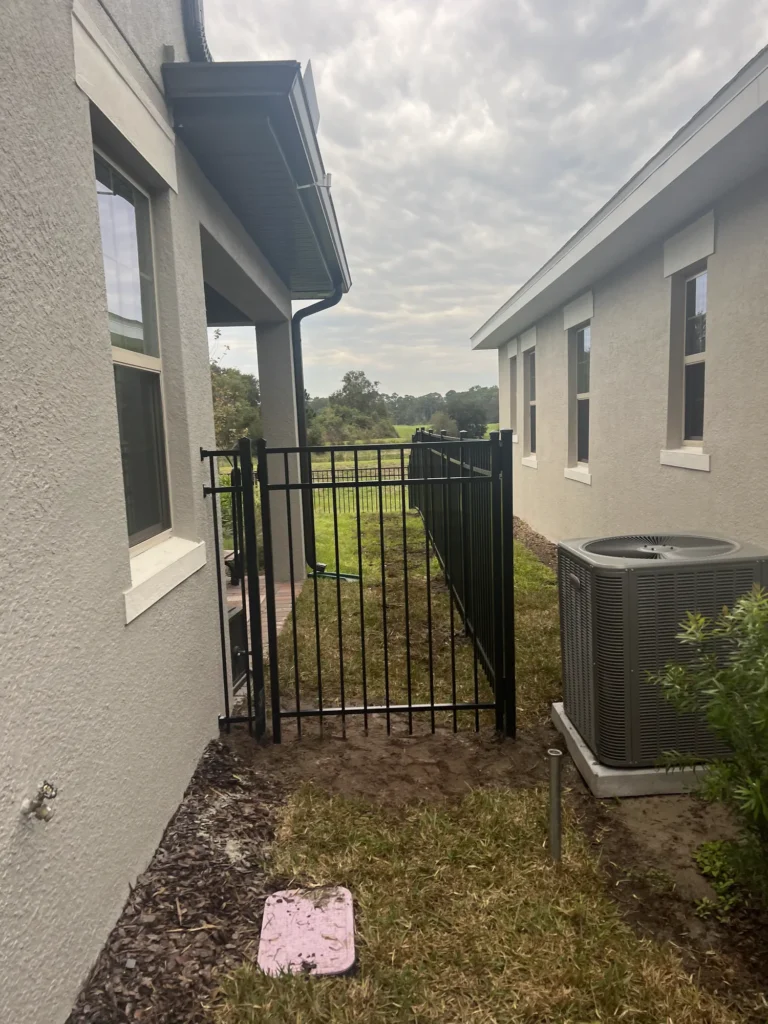 Black aluminum fence and walk gate along the side yard of a new Florida home