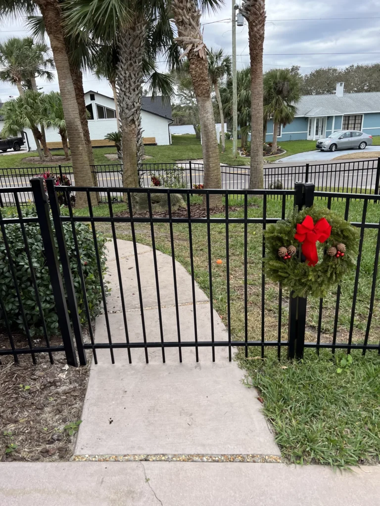 Black aluminum front yard fence and walk gate at a Florida home