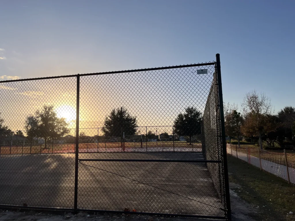 Black chain link gate and fence panel at a public recreation complex