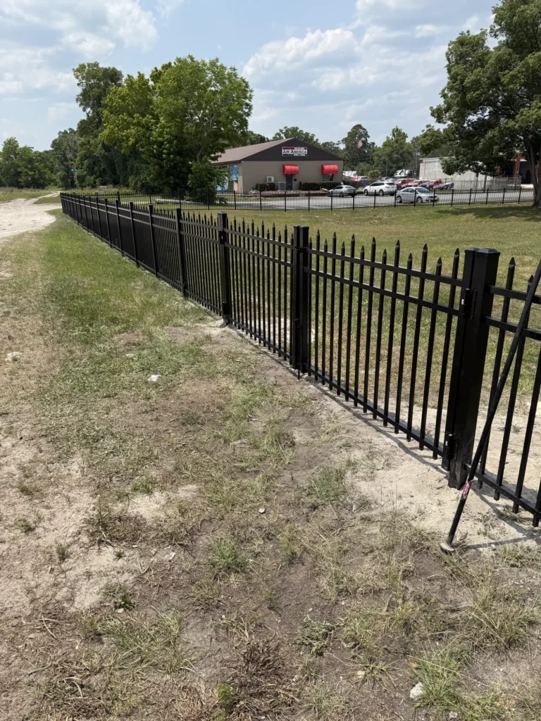 Black aluminum spear-top fence securing a commercial property line