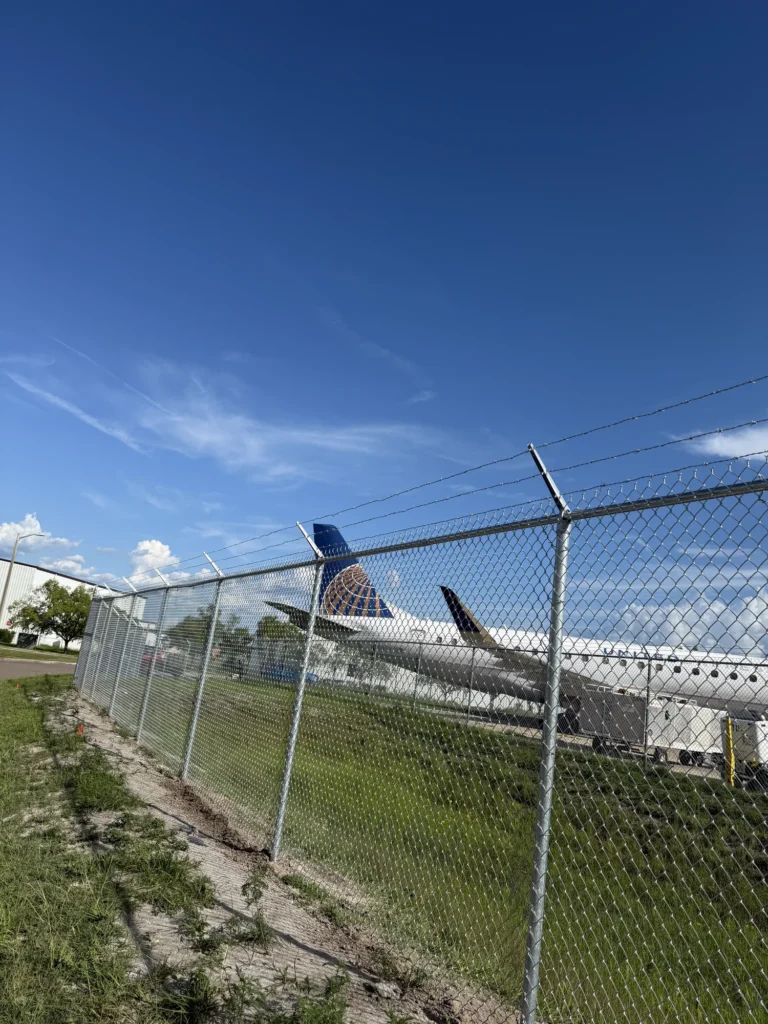 Barbed wire topped chain link fence securing an aircraft ramp