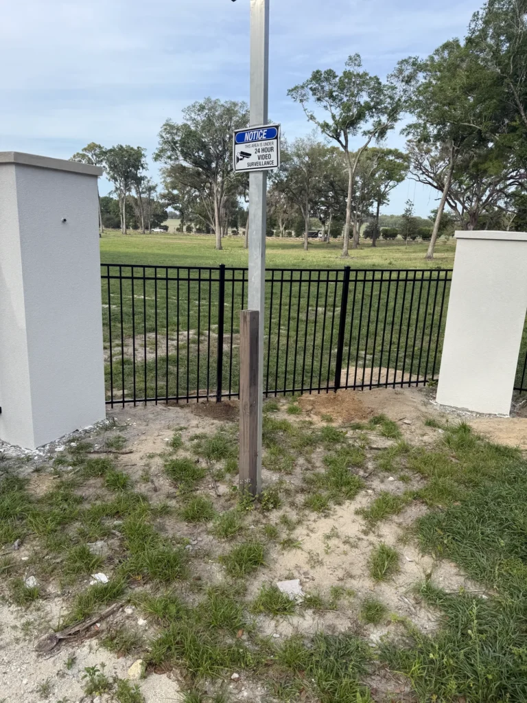 Black aluminum estate fence with video surveillance signage