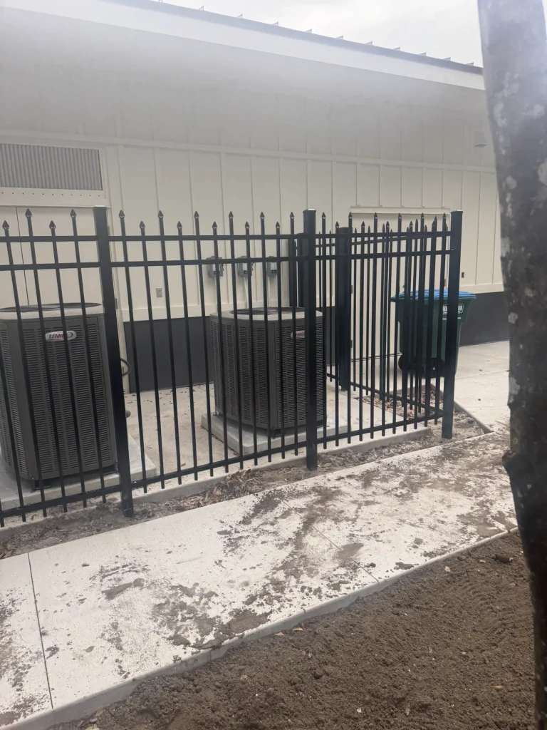Black aluminum equipment screen fence at a commercial property