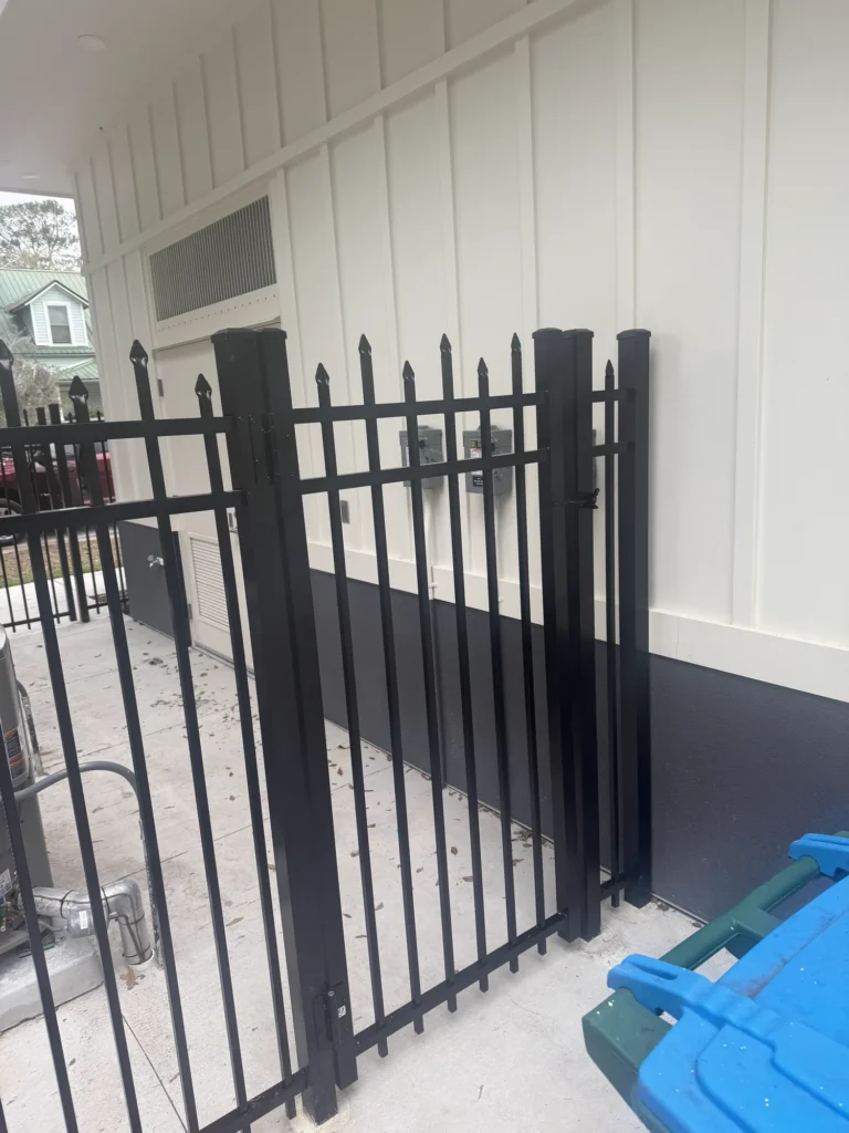 Black aluminum spear-top gate on a commercial equipment enclosure