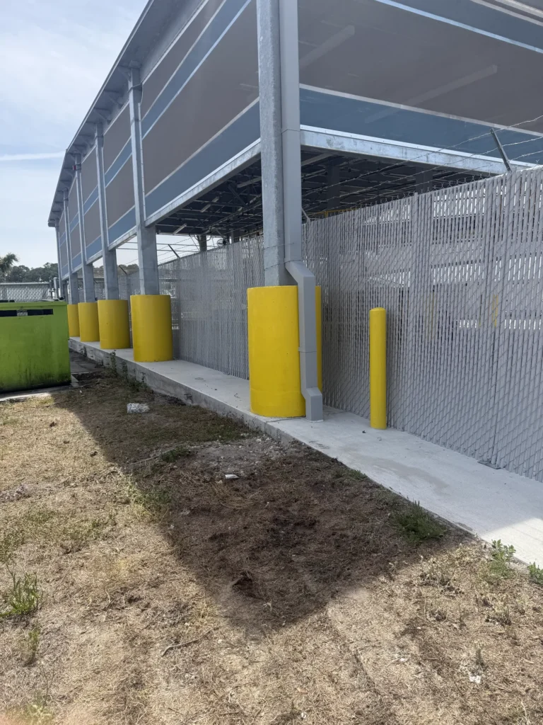 Chain link fence with gray privacy slats screening a commercial service area