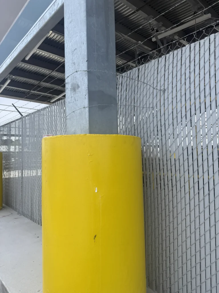 Privacy slat chain link security fence with barbed wire