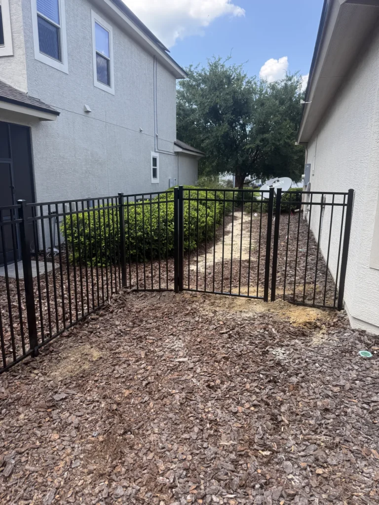 Black aluminum side yard fence and gate between two homes